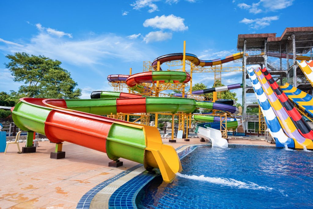 Swimming pool with water slides in aqua park on sunny day. summer fun activity, vacation leisure concept.